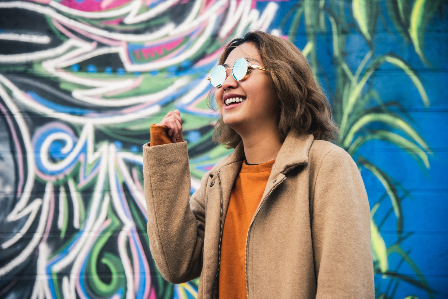 woman smiling by graffitti